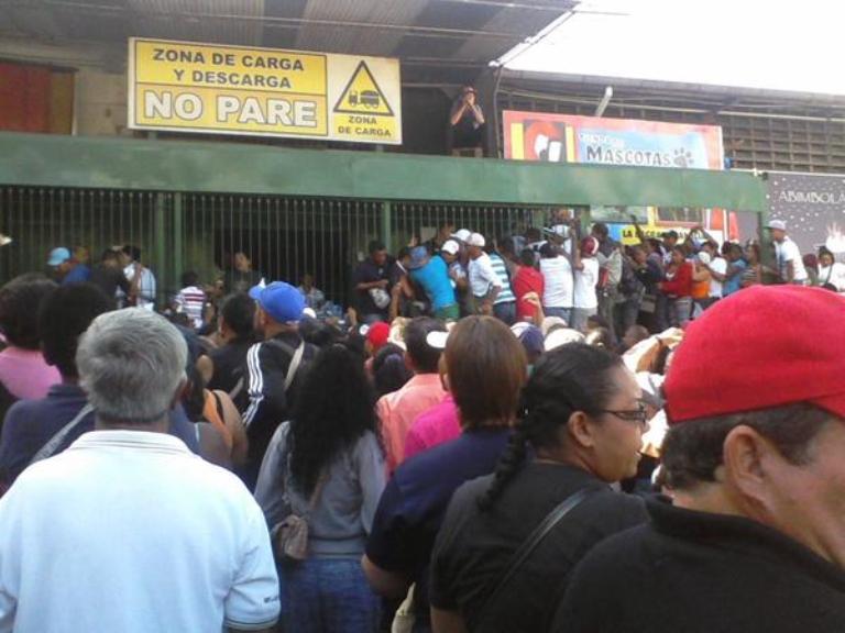 Personas intentan comprar leche a las afueras de un hipermercado en Guarenas, ciudad dormitorio de la capital 
