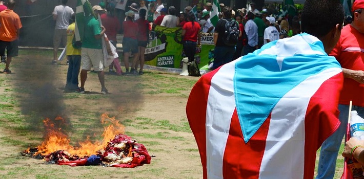 Manifestantes quemaron una bandera de Estados Unidos. (El Nuevo Día)