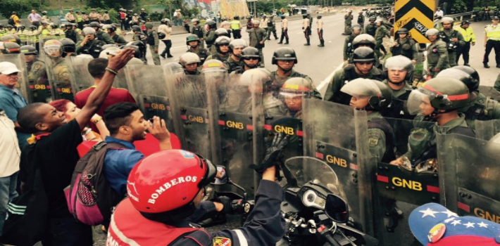 The Venezuela National Guard use anti-riot gear to prevent the passage of opposition activists demanding a Venezuelan recall referendum on Nicolás Maduro