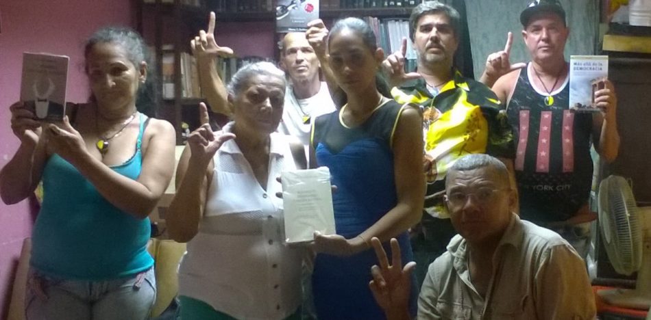 Yanet aparece en el medio (de azul) en la sede, junto a integrante del Partido Libertario Cubano que fueron detenidos la semana pasada. Sostienen libros que pregonan la libertad.