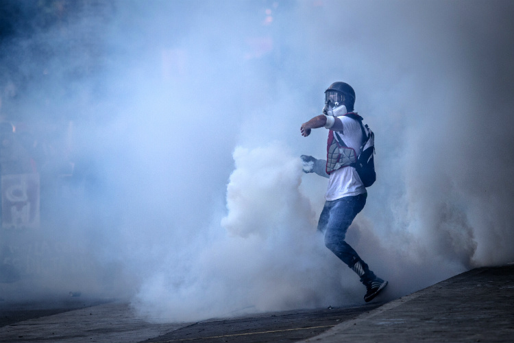Joven de la resistencia devuelve bomba lacrimógena. (Leo Álvarez)