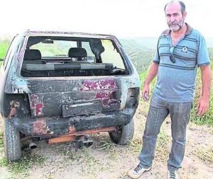 Joao Miranda junto a su carro que fue incendiado en 2014 (Reporteros sin Fronteras)
